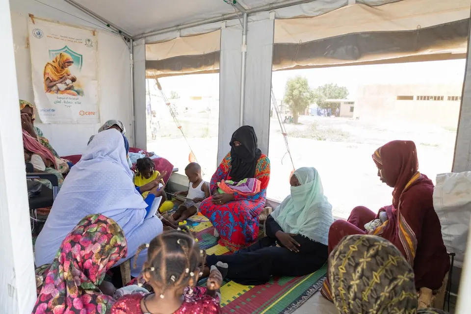 Mothers holding babies and children wait to see health workers at a UNICEF-supported clinic in Kassala state, Sudan.