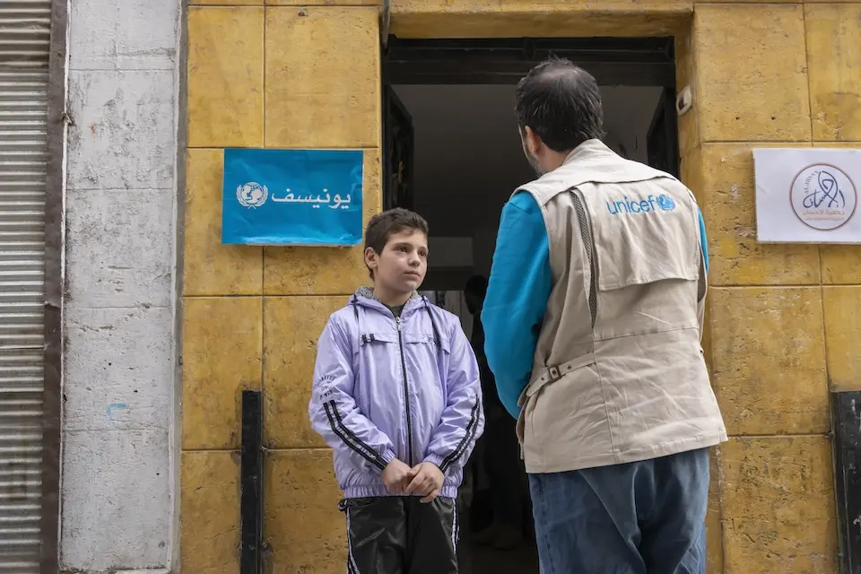 Mohamed, 11, chats with a UNICEF staff member in front of a UNICEF-supported child protection center in Aleppo, Syria, on Dec. 5, 2024.