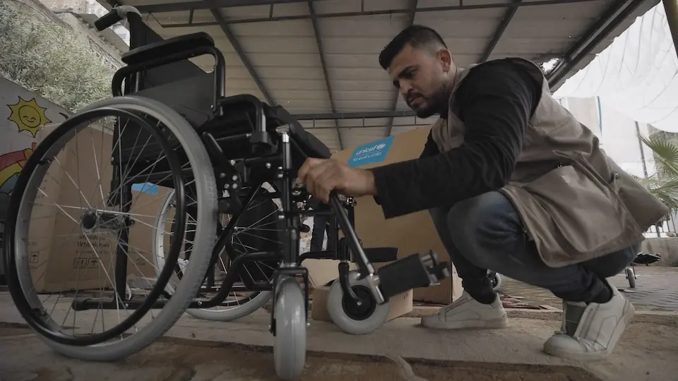 A UNICEF staff member assembles a wheelchair, part of a delivery for children in need in North Gaza.