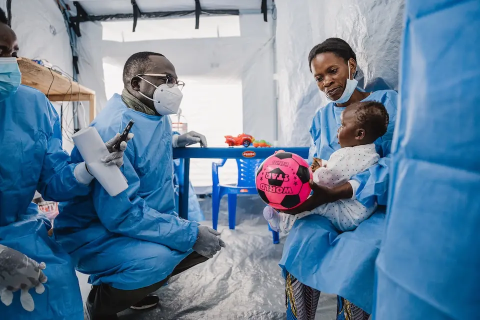UNICEF DRC’s acting Representative Jean-François Basse plays with a baby girl at the UNICEF-supported crèche near the mpox treatment center in Lwiro, South Kivu province, DRC, on Jan. 17, 2025.