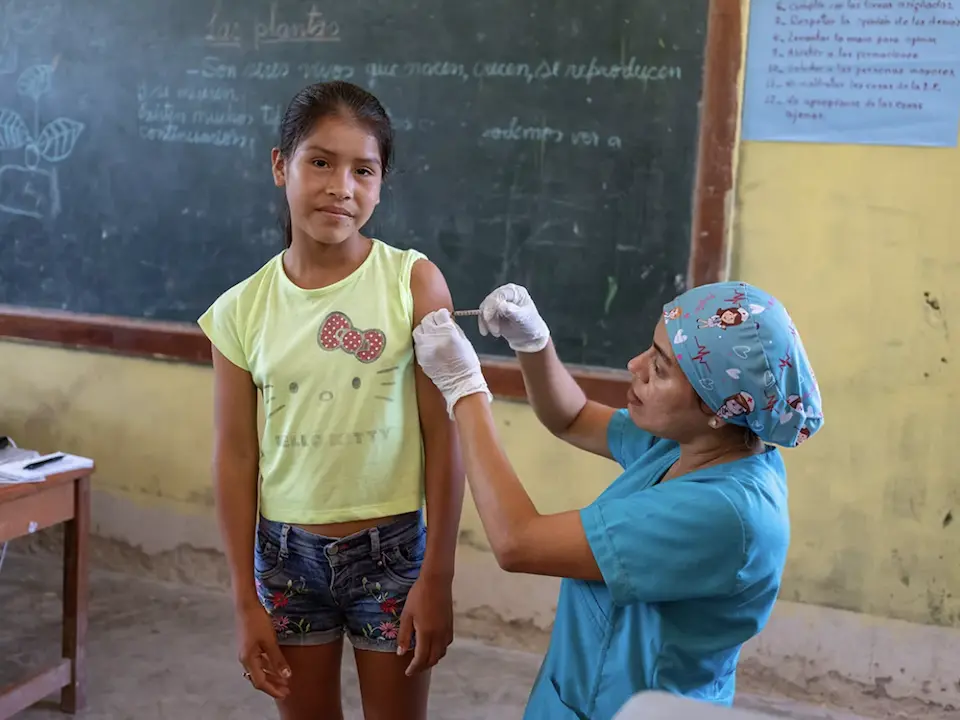 In Peru, 12-year-old Jossi is vaccinated against the papillomavirus by nurse Maribel Vilela Grandez, who works for the UNICEF-supported health brigade.