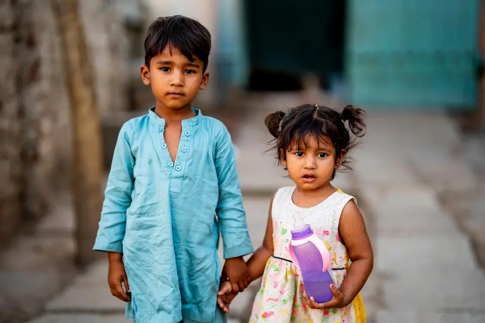 Siblings stand outside their home on May 28, 2024, a 116 degree day in in Faisalabad, Punjab, Pakistan.