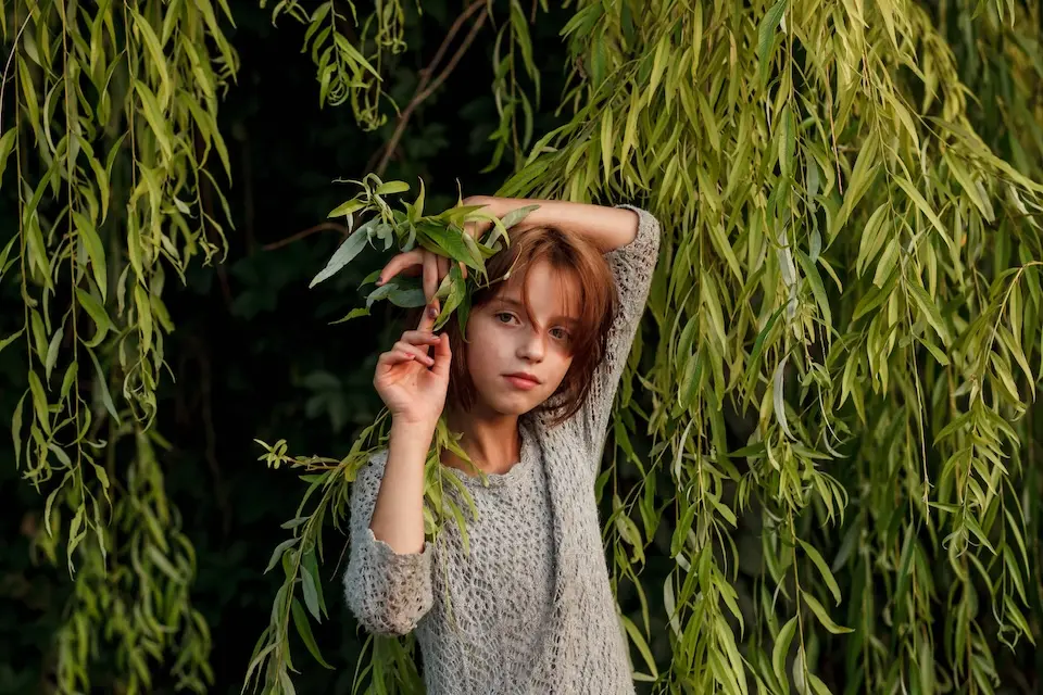 In Kryvyi Rih, Ukraine, 11-year-old Anhelina, who was able to return home to live with her mother and siblings with support from UNICEF, stands under a willow tree.
