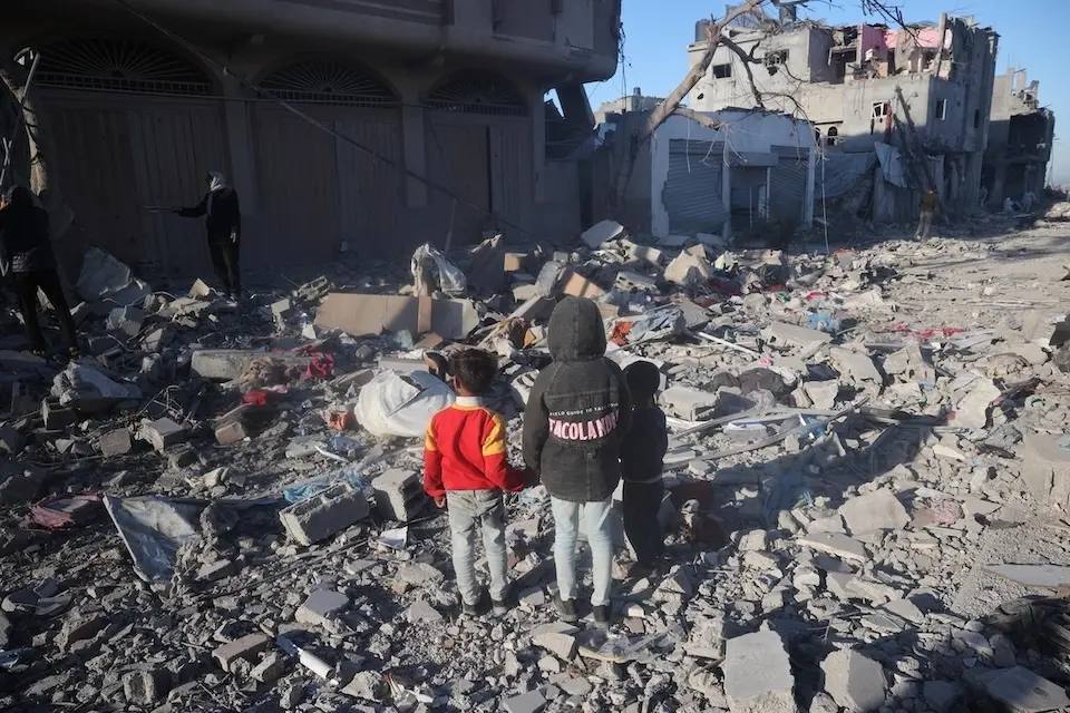 On January 21, 2024, children stand amidst the rubble of their destroyed home in Rafah, Gaza Strip.