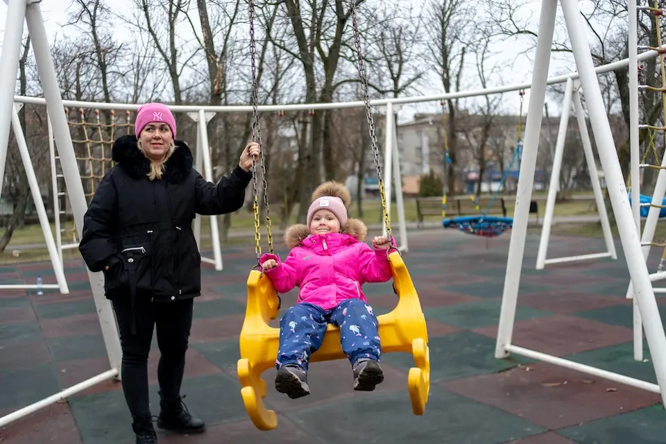 On Jan. 26, 2025, 3-year-old Katya smiles as her mother, Alyona, gently pushes her on a swing in their hometown of Balakliia, Kharkiv region.