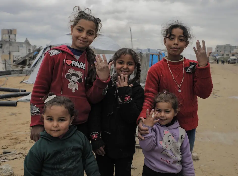 Children in Jabalia, northern Gaza, show their fingers, marked to indicate they received the polio vaccine during a mass vaccination campaign in February 2025.