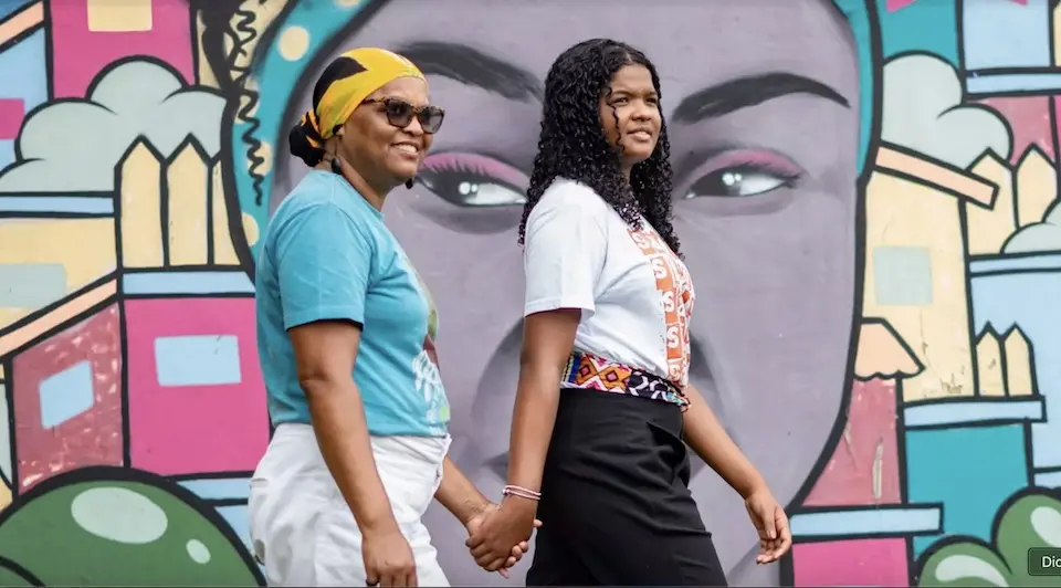 A mother and daughter walk hand in hand in Brazil.