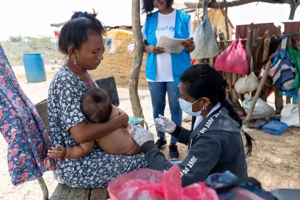 Community health worker Esperanza vaccinates a young boy in the community of Marilou, in La Guajira, one of the poorest departments in Colombia.