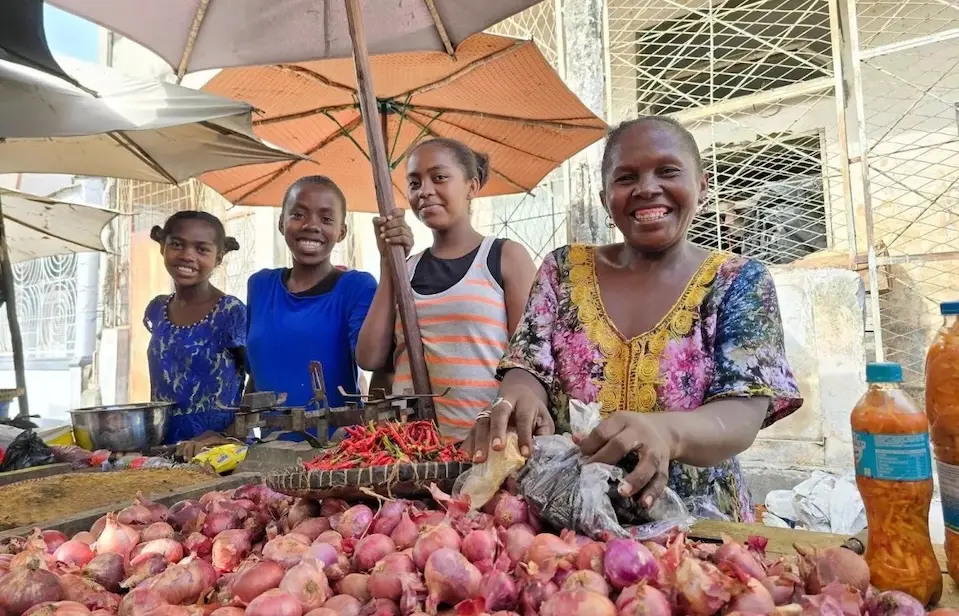 Louisette, 45, and her three daughters at the vegetable market in Madagascar.