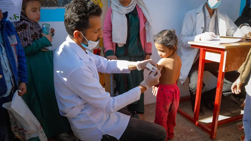 Munira, 4, is screened for malnutrition by a UNICEF mobile team member in Yemen.