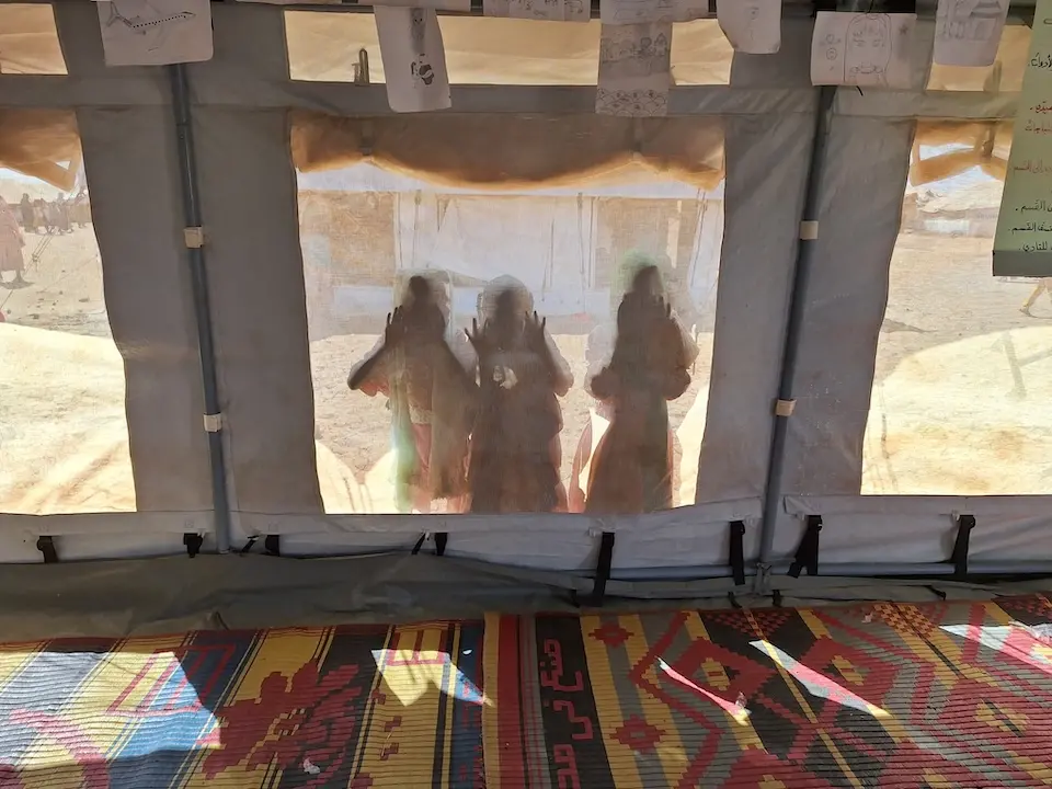 On Dec. 3, 2024, children peer through a UNICEF tent at a child-friendly space in Kassala state, Sudan.