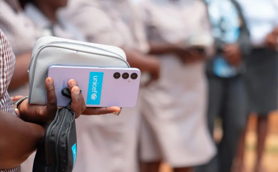 Female Village Health Worker in Zimbabwe holds the smartphone she carries to take notes and transmit health data