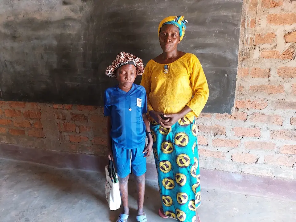 Fourteen-year-old Davilaine, who is blind, stands next to her mother at school in the Central African Republic.