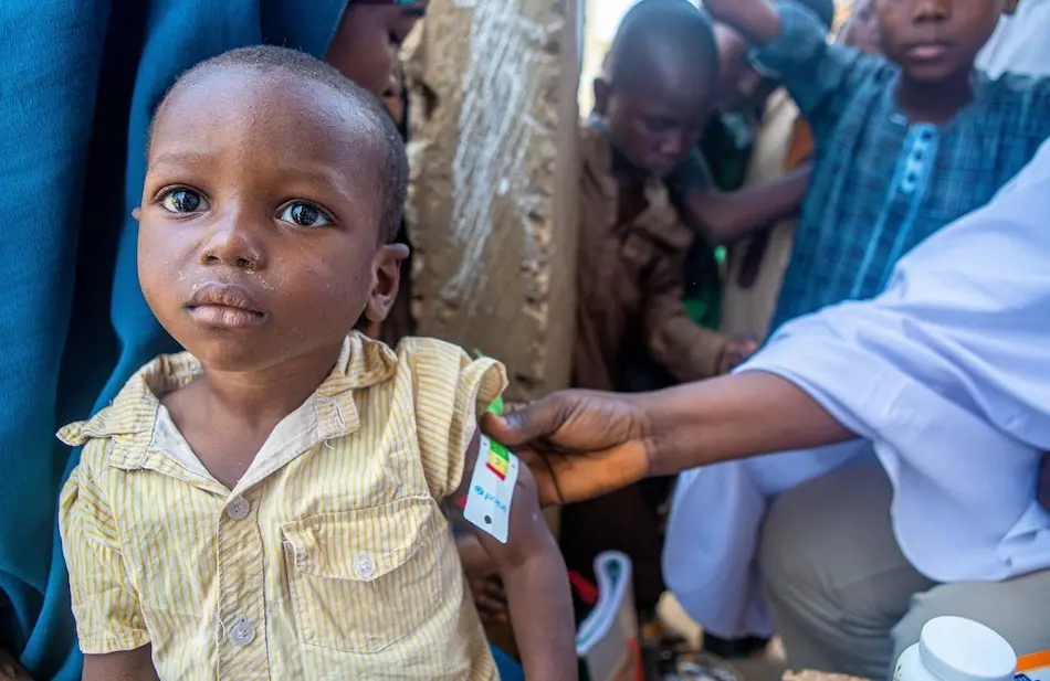 Umma, 4, is being screened for Severe Acute Malnutrition (SAM) by measuring her mid-upper arm circumference at the Integrated Mobile Outreach site in northern Nigeria.