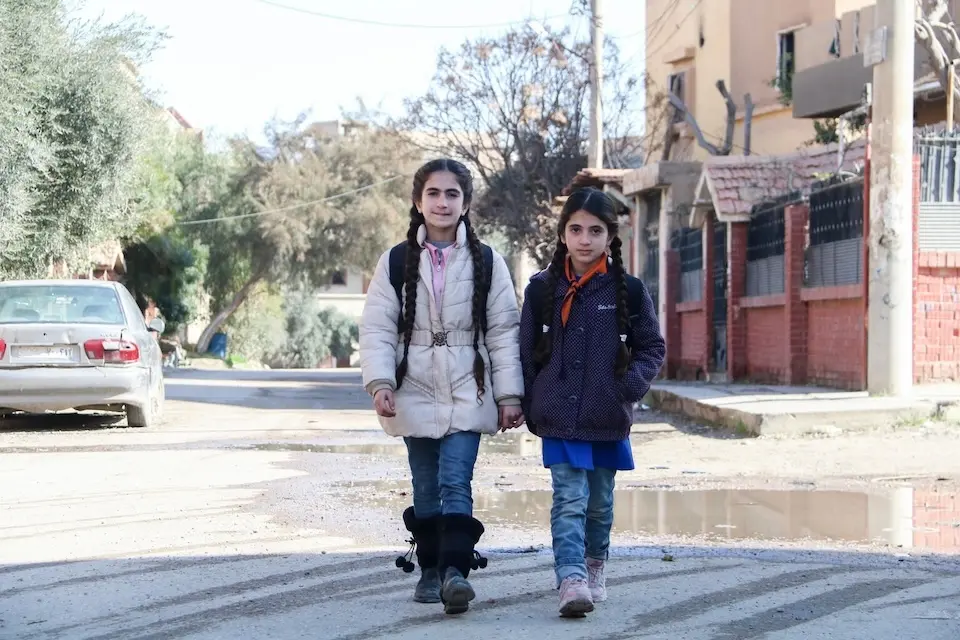 Sisters walk to school in Deir-ez-Zor city, northeast Syria, on 6 Feb. 6, 2024.