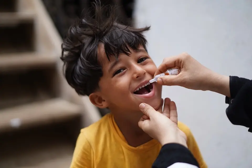 A boy in Yemen smiles as he receives the oral polio vaccine.
