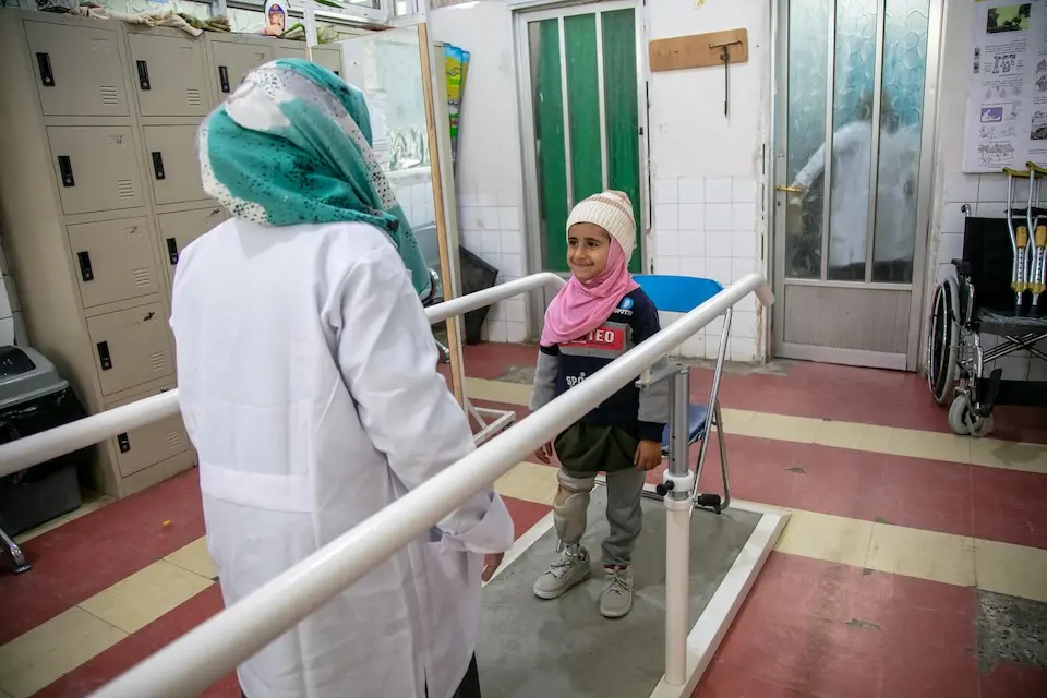 Dr. Afrah Al-Harassi helps Khadija, 9, learn to walk with her prosthetic limb in Sana'a, Yemen.