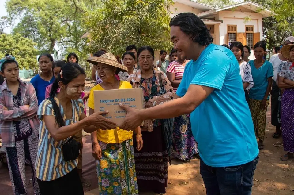 On March 31, 2025, UNICEF’s Sai Han Lynn Aung (Ko Sai), Chief of the UNICEF field office in Mandalay, delivers a box of WASH supplies to a resident of the Sagaing Region.