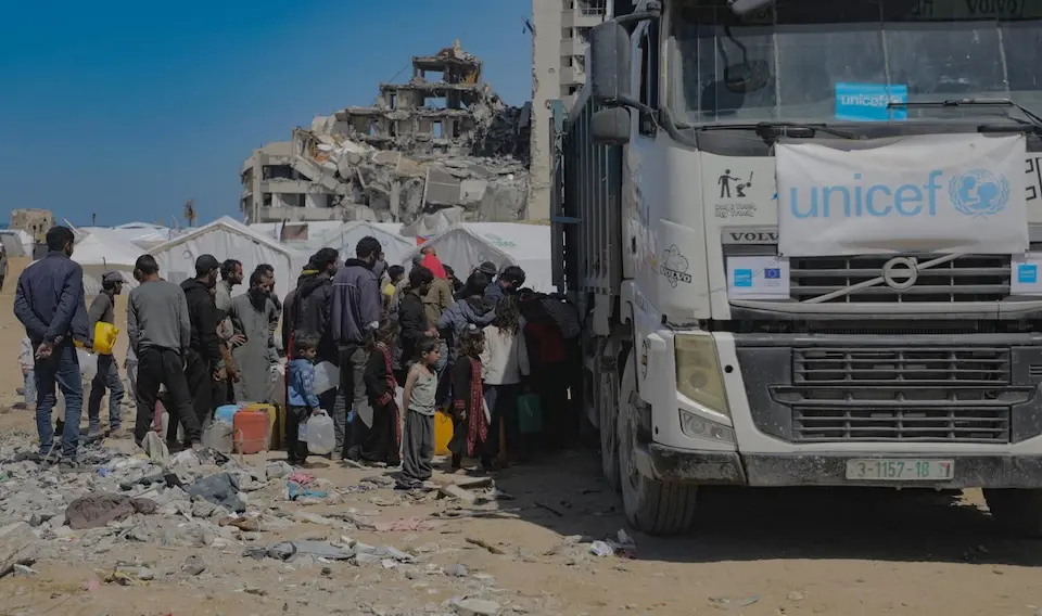 Children and their families gather around a UNICEF truck distributing safe water at Beach Camp, Gaza City, State of Palestine, on March 24, 2025.