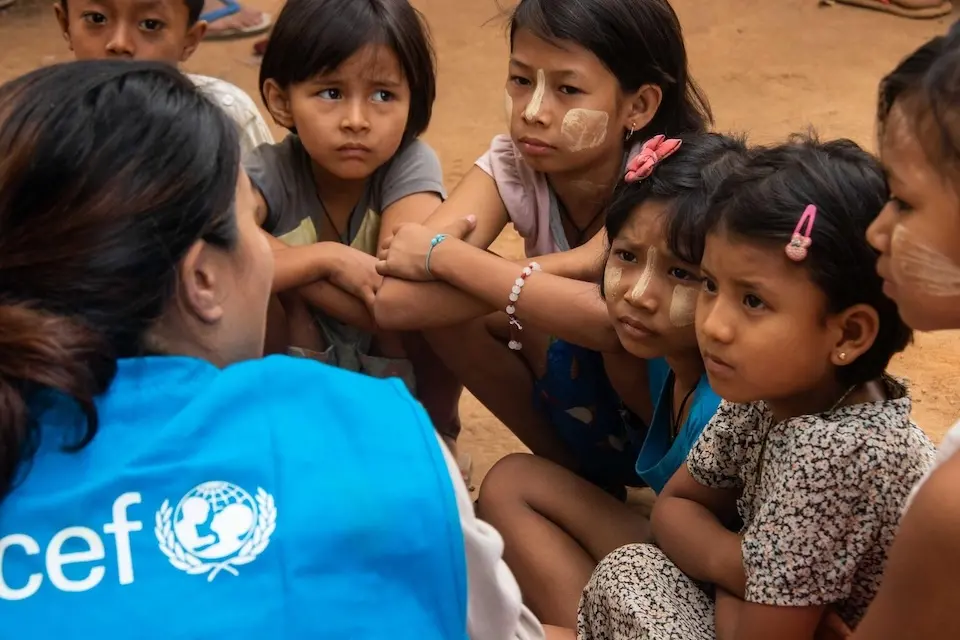 On April 5, 2025, Khet Mar, UNICEF Child Protection Officer, meets with children devastated by the recent earthquake during a UN inter-agency joint distribution at a temporary camp in Chan Thar Kone village, Sint Kaing township, Mandalay region, Myanmar.