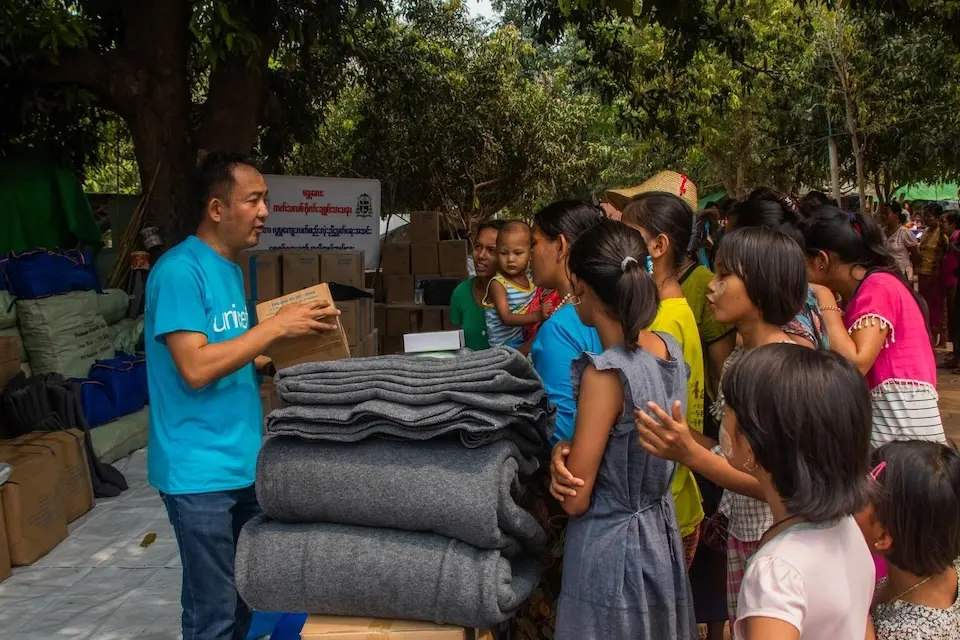 On April 5, 2025, Kyaw Thet, UNICEF WASH Officer, distributes hygiene kits to communities devastated by the recent earthquake during a UN inter-agency joint distribution at a temporary camp in Chan Thar Kone village, Sint Kaing township, Mandalay region, Myanmar.