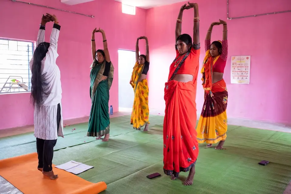 At a health and wellness center in India, a practitioner leads women through yoga designed to help promote physical and mental health during and after pregnancy.