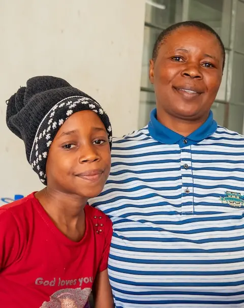 Young girl and her mother smiling at camera at Kadoma General Hospital in southwest Zimbabwe.