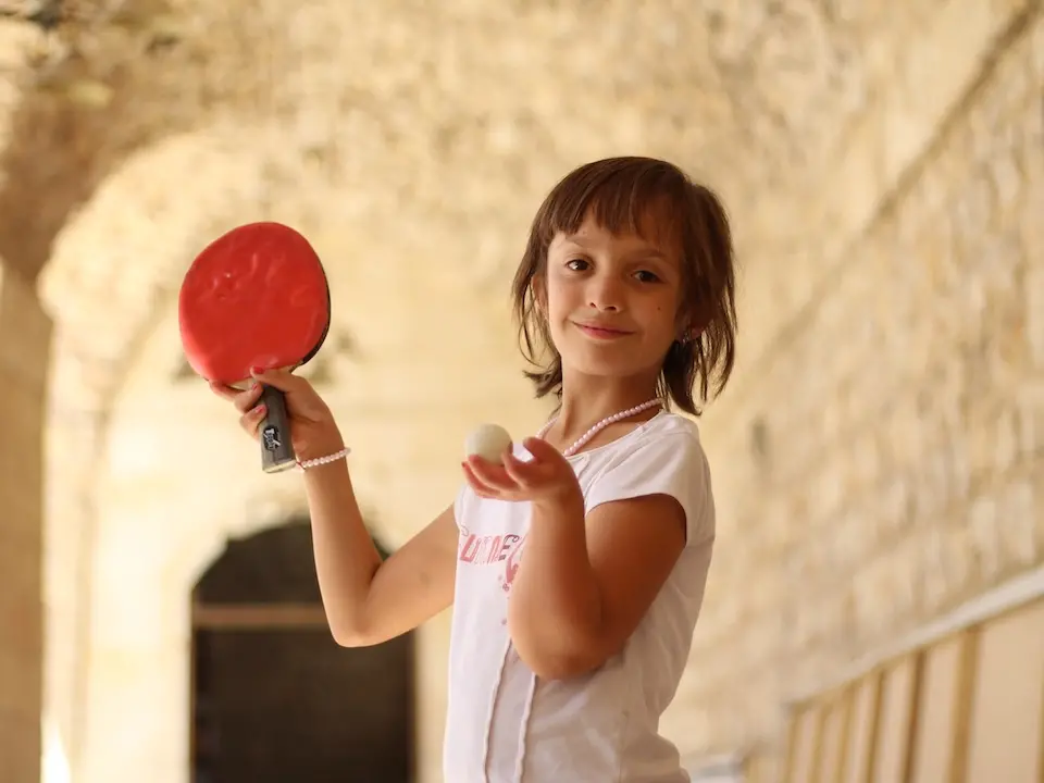 11-year-old Bayan plays table tennis at a UNICEF-supported shelter for displaced families in western Aleppo City.