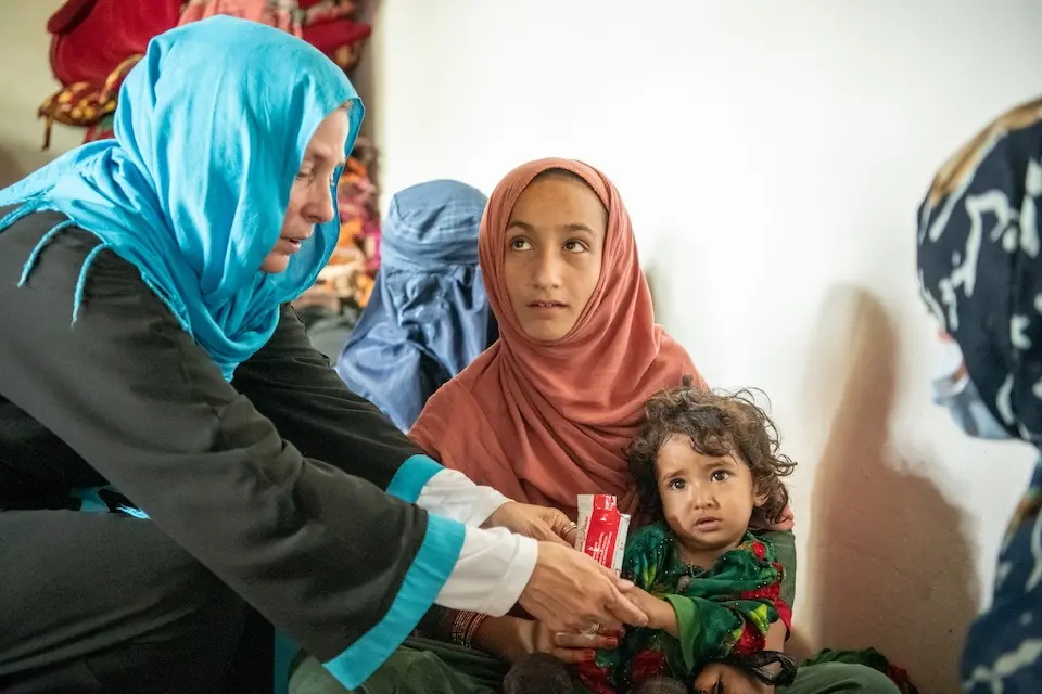 A malnourished child receives RUTF from a member of a UNICEF-supported mobile nutrition team in Kunar, Afghanistan.