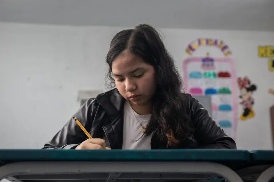 A teenage immigrant from Venezuela attends school in Peru with support from UNICEF and ECW. 