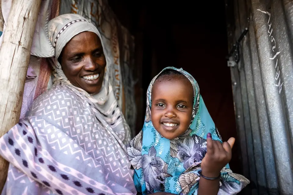 In the Somali region of Ethiopia, a mother holds her smiling 4-year-old daughter, who has just received her polio vaccine during a UNICEF-supported national campaign.