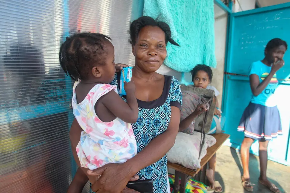 A mother and three of her four children stand outside a site for displaced people in Port-au-Prince, Haiti on March 18, 2025.