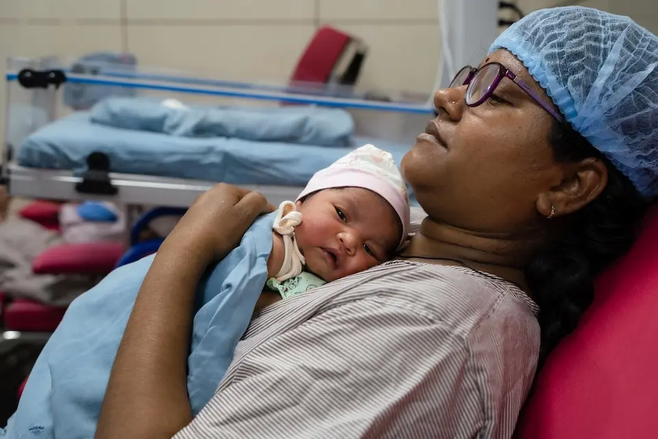 A mother holds her newborn in the step-down unit at UNICEF-supported GMERS Civil Hospital, Sola, Gandhinagar, Gujarat, India.