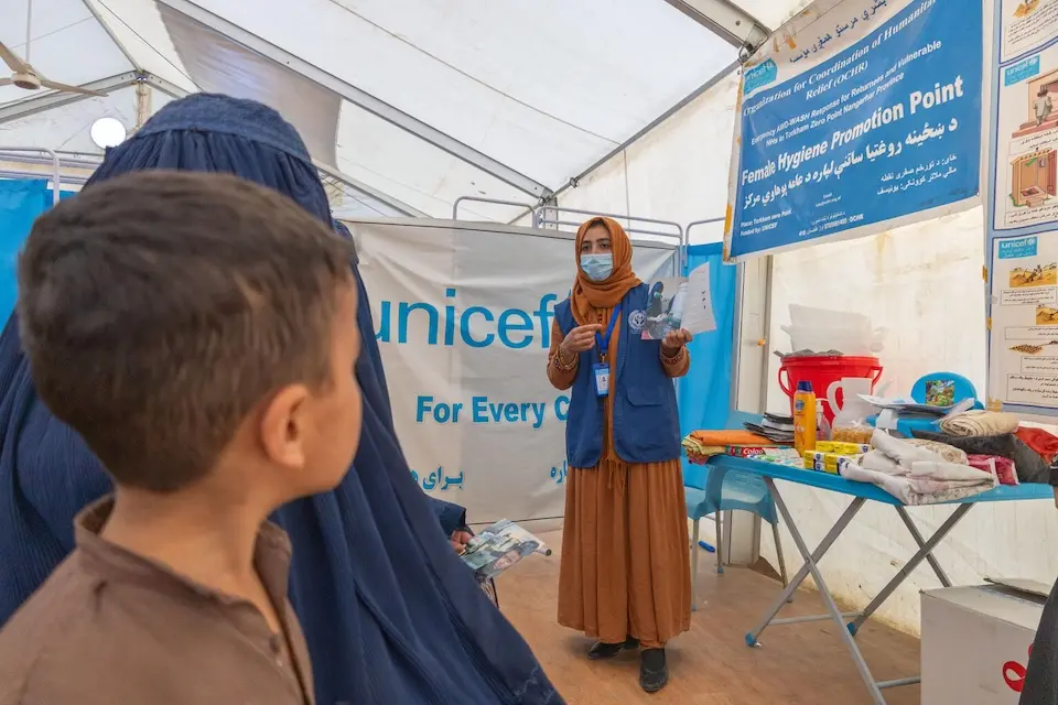 At Afghanistan's eastern Torkham border, a UNICEF partner conducts a hygiene awareness session with women who have just returned from Pakistan and received a hygiene kit as part of their arrival package.