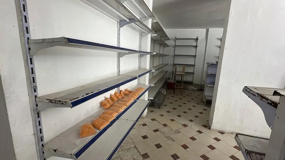 On May 12, 2025, shelves sit nearly empty in a shop in Khan Younis, southern Gaza Strip.