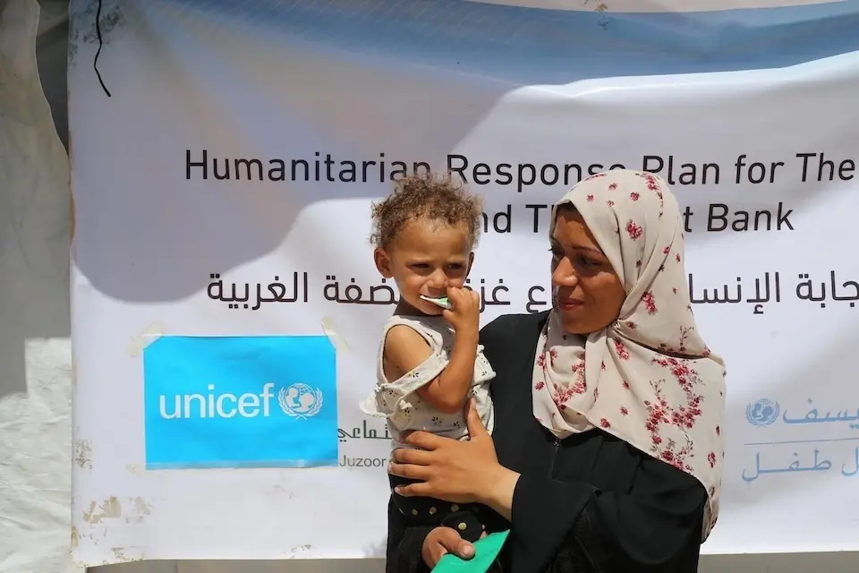 A mother holds her malnourished 1-year-old daughter outside a UNICEF screening and treatment center in the Gaza Strip.