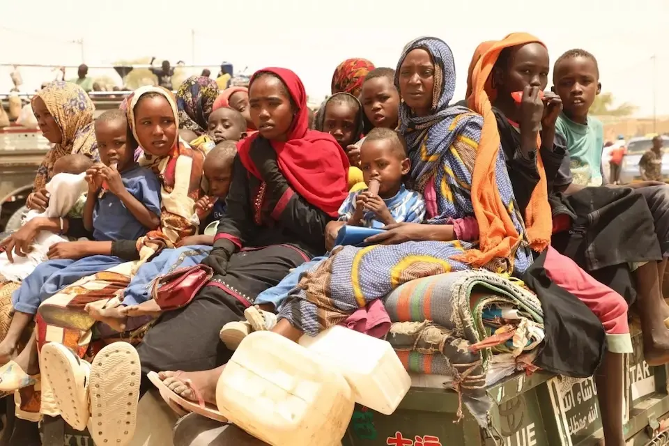 A vehicle carrying mothers and children crosses the border from Sudan into Chad.