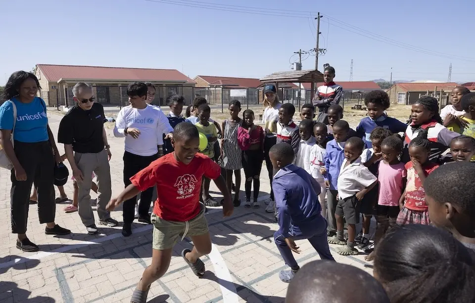 UNICEF visitors play with youth at a safe park in South Africa.