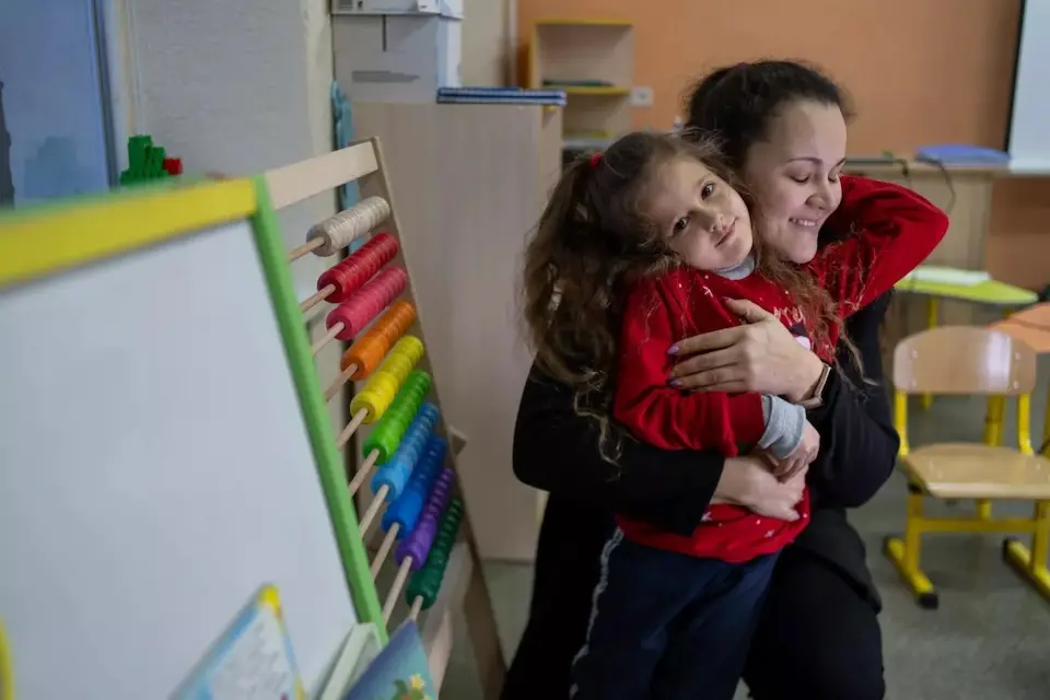 A mother hugs her daughter in a UNICEF-supported early childhood class in Ukraine.