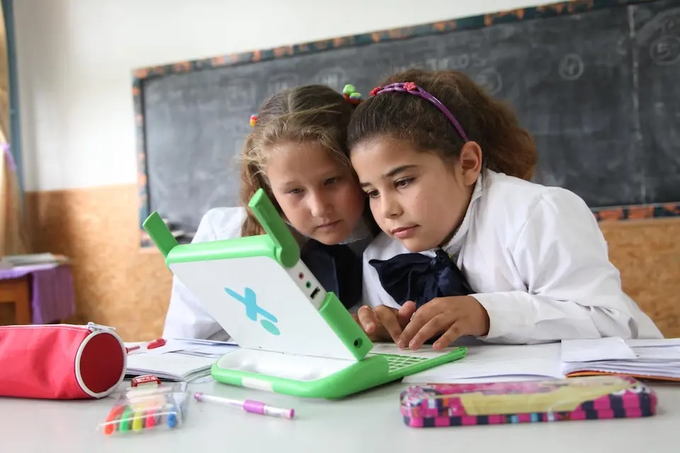 Two children in Uruguay use a special accessible laptop. 
