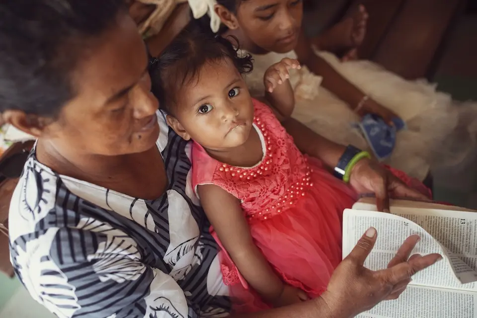 A parent and child attend church services in Tuvalu.