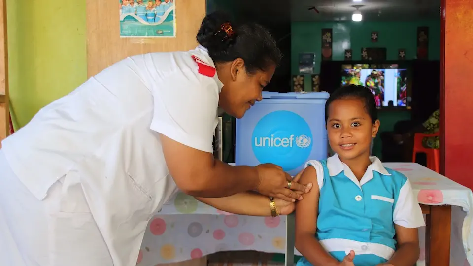 UNICEF-supported health worker in Tuvalu vaccinates a 10-year-old girl at her primary school.