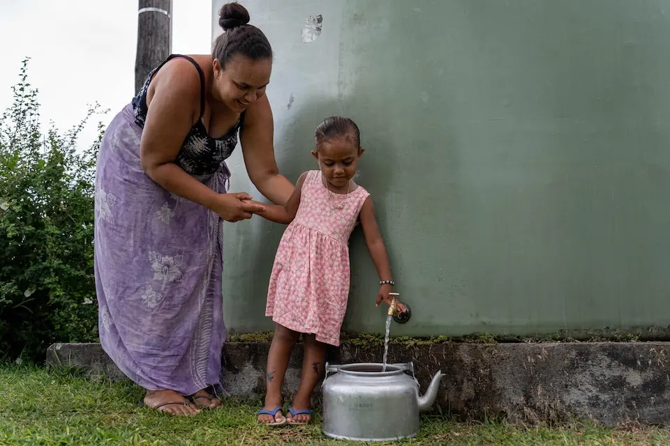 A mother and daughter in Vanuatu access water provided by UNICEF after an earthquake