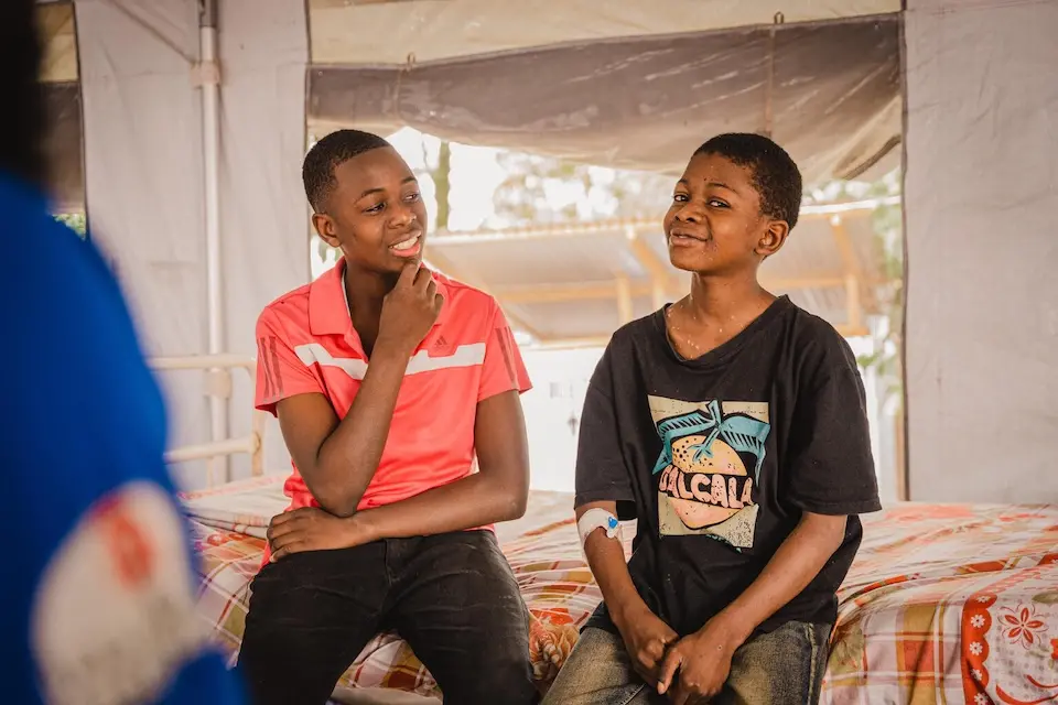 Two young brothers being treated for mpox at a UNICEF-supported clinic in the Democratic Republic of Congo