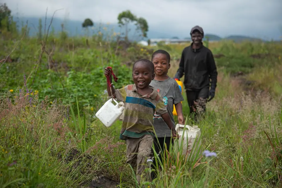 A father and his sons head to the water point set up by UNICEF in Bushagara in the Nyiragongo health zone near Goma, North Kivu province, DR Congo.