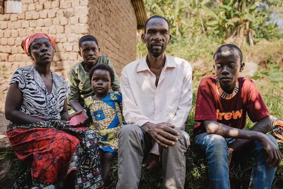 A family of five sit outside their home in South Kivu province, DR Congo, on May 1, 2025.