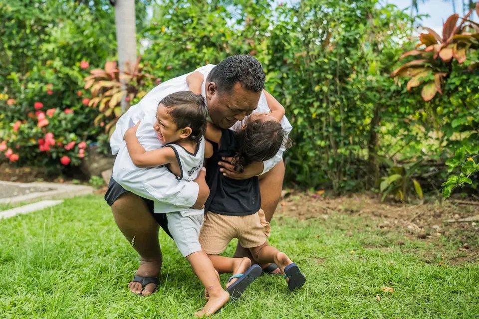A father plays with his kids in the village of Vaitele in Apia, Samoa.