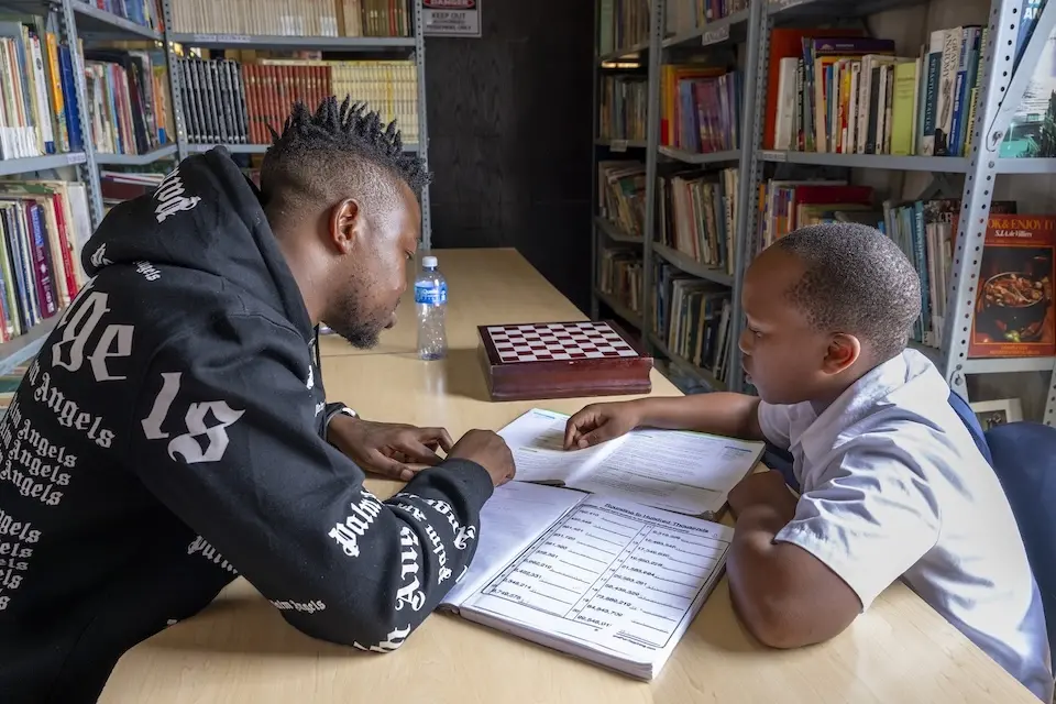 A teenager tutors a young boy at a UNICEF-supported safe park in South Africa