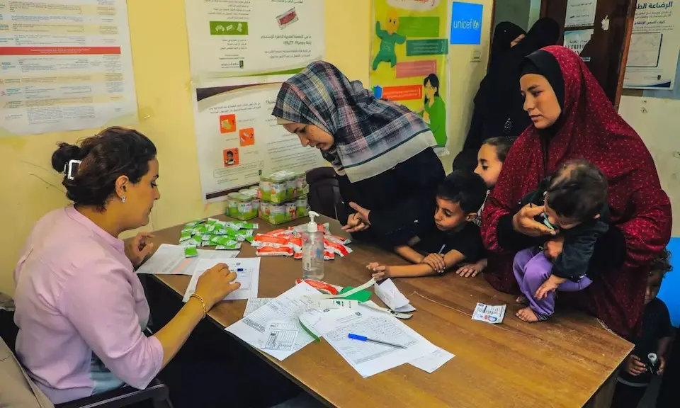 A UNICEF-supported health worker provides mothers in the Gaza Strip with RUTF and nutritional information for their children.