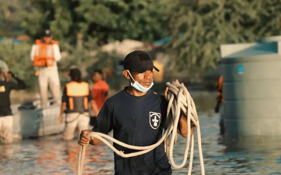 A volunteer helps secure lwater tanks outside the city limits of Dili in Timor-Leste after the devastating 2021 floods.